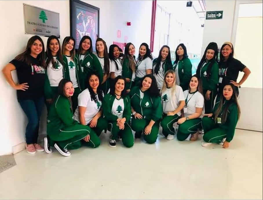 Equipe escolar reunida usando camisetas e conjuntos verdes e brancos
